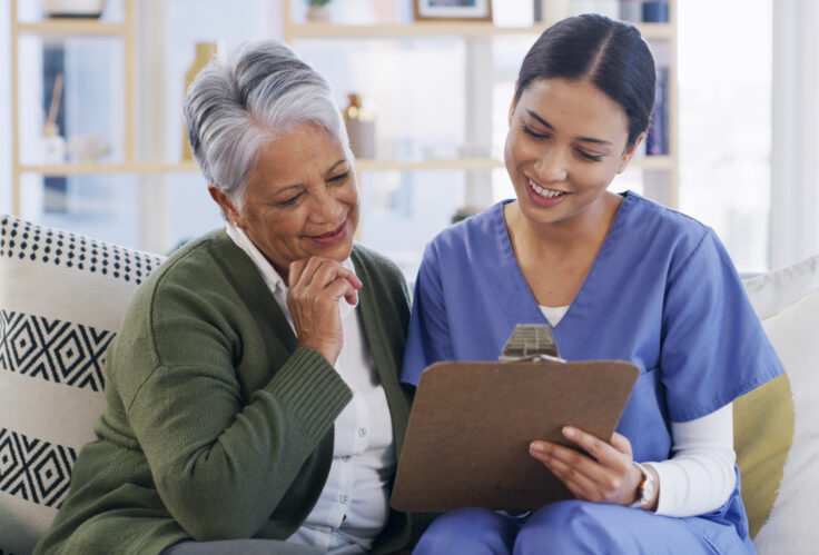 A nurse meets with a senior woman to discuss her medical evaluation, which is supplemented by Medicare Part A & B